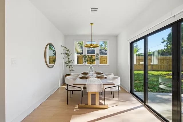 a dining room with wooden floor a glass table and chairs