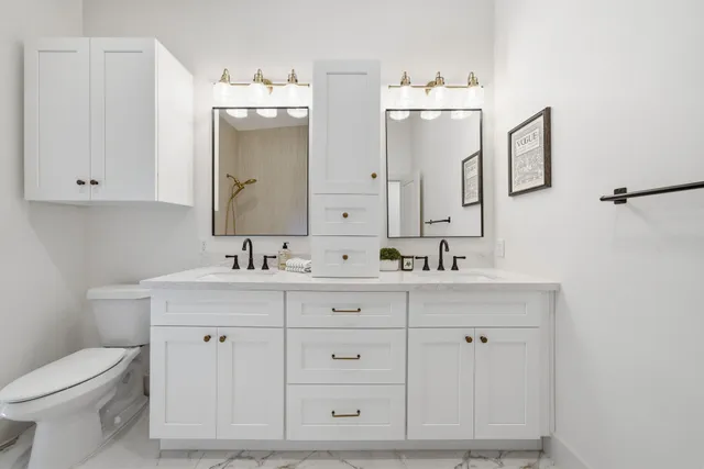 a bathroom with a toilet a sink a mirror and vanity