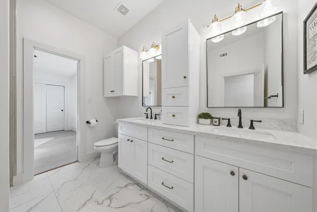 a bathroom with a toilet a sink a mirror and a shower