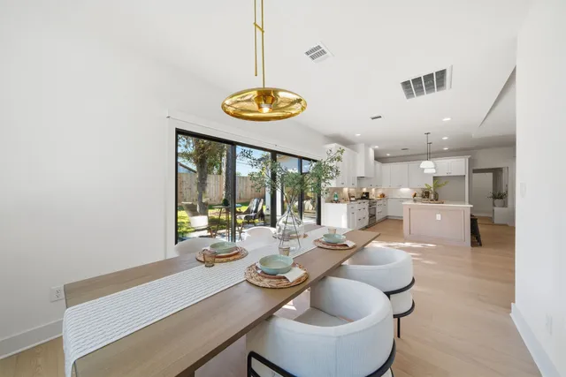 a view of a dining room and livingroom with furniture wooden floor and a large window