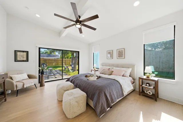 a spacious bedroom with a bed couch and window