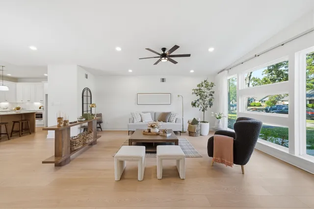 a living room with fireplace furniture and a large window