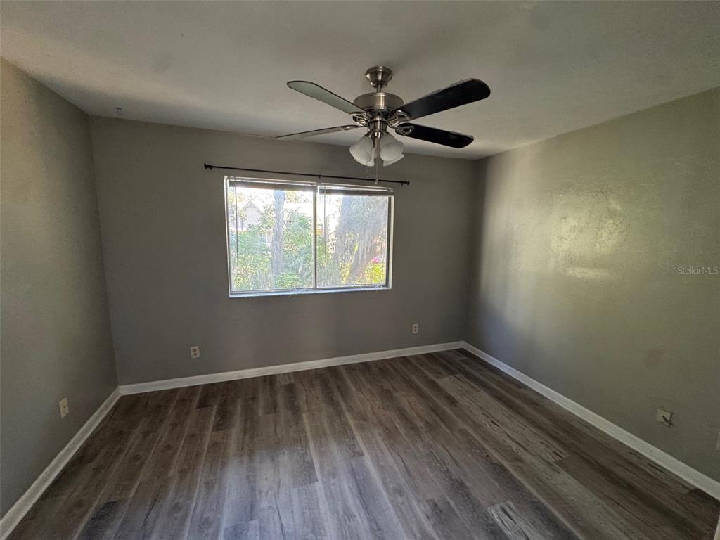 4411 Southwest 34th Street, Unit 1001 Gainesville, FL 32608 - Photo 19 of 20 a view of an empty room with wooden floor and a window