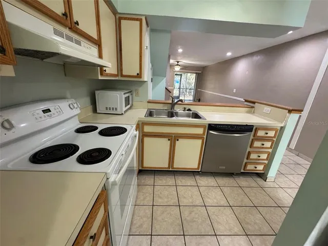 a kitchen with a sink a stove top oven and cabinets