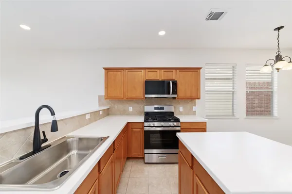 a kitchen with a sink a counter top space appliances and cabinets