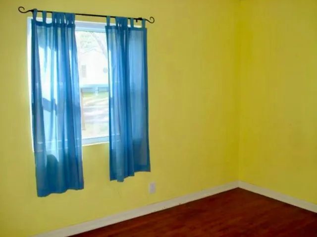 a view of a room with wooden floor and windows