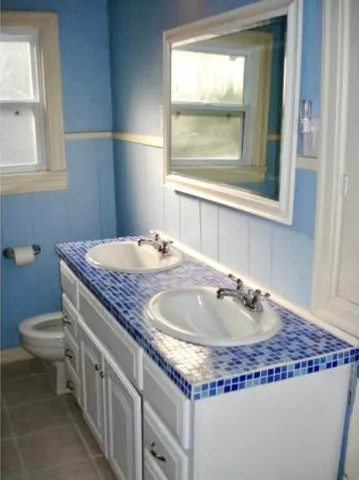 a bathroom with a granite countertop sink and a toilet