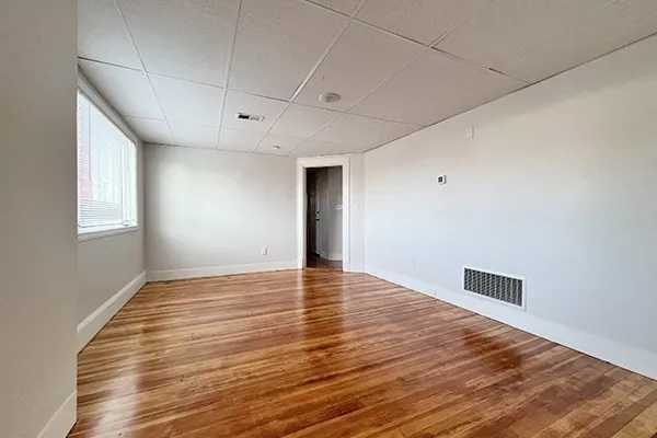 a view of empty room with wooden floor