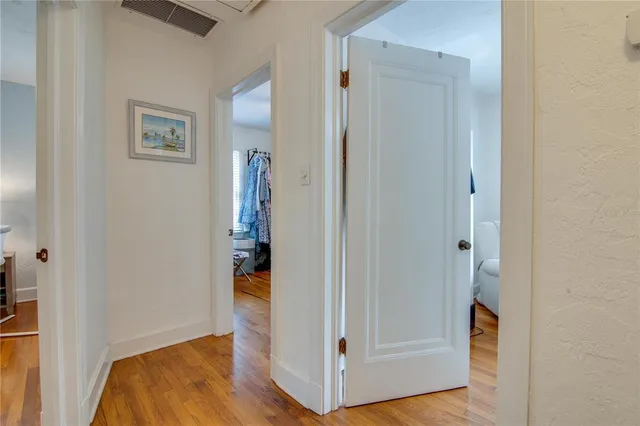 a view of a hallway with wooden floor and entryway