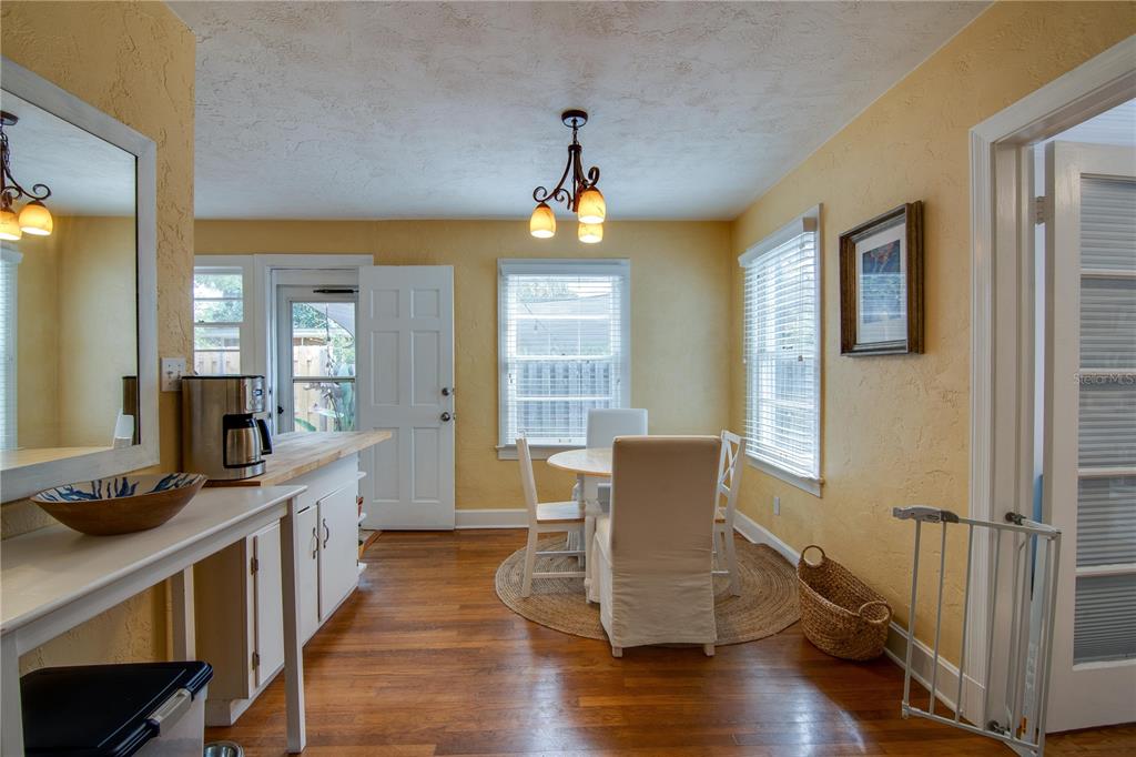 407 Northeast 8th Street Gainesville, FL 32601 - Photo 24 of 32 a dining room with wooden floor a chandelier a wooden table and chairs