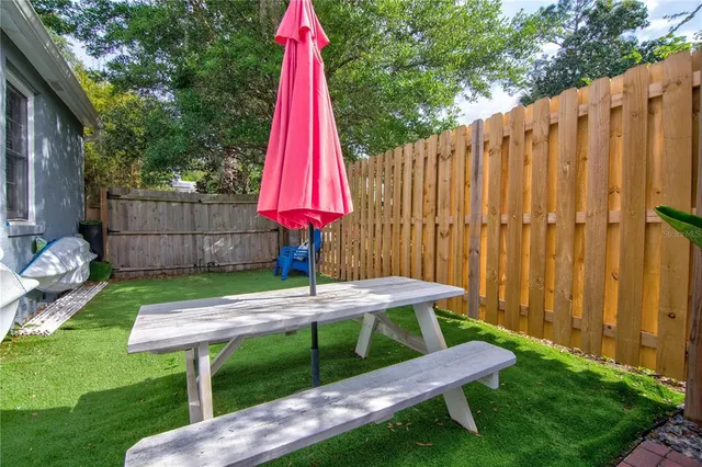a view of a backyard with a swing and wooden fence