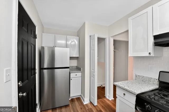 a kitchen with a refrigerator stove and wooden cabinets