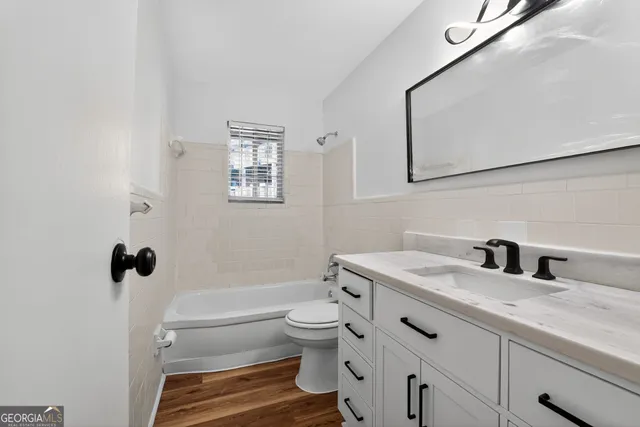 a bathroom with a double vanity sink toilet and shower