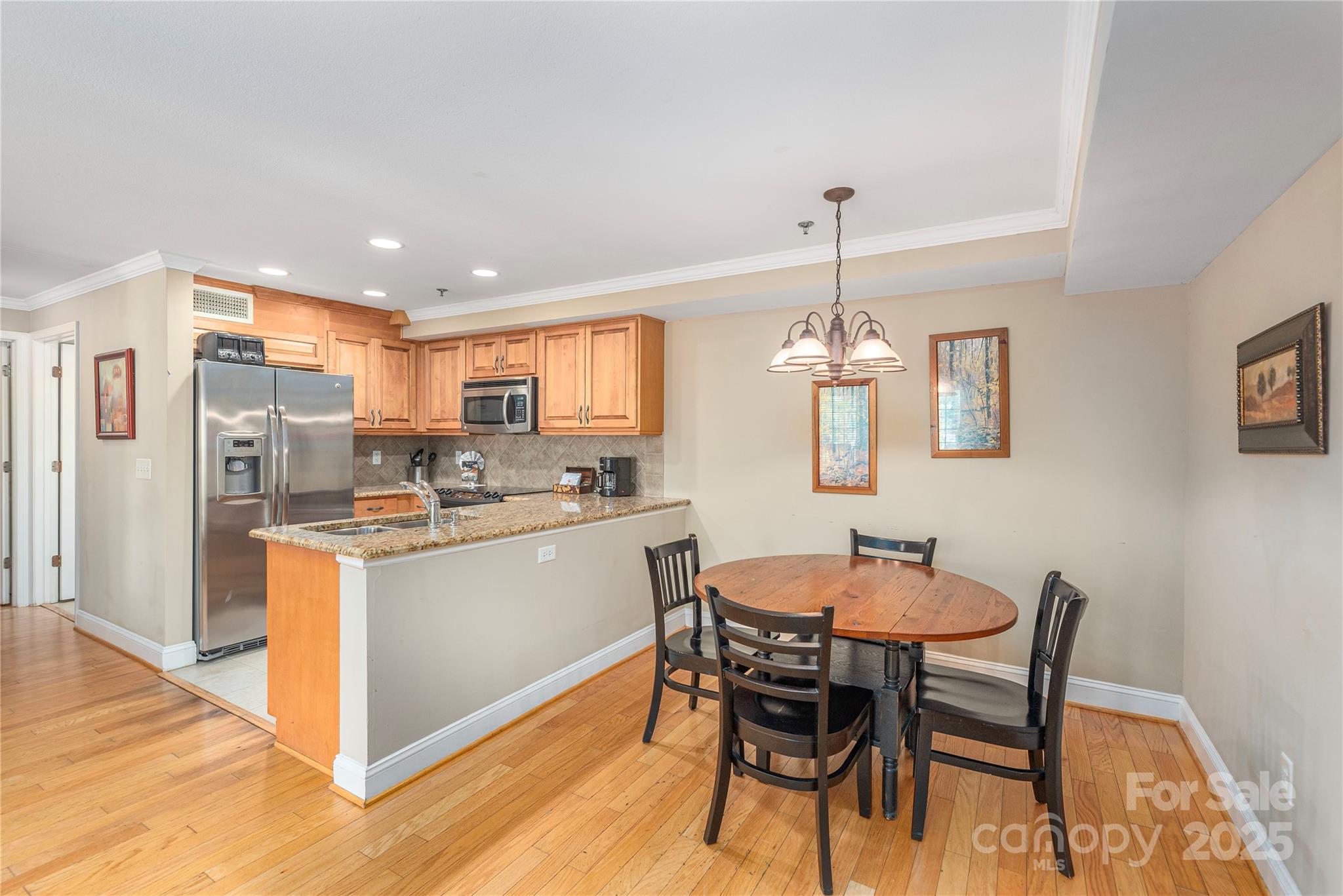 114 Bowling Park Road Asheville, NC 28803 - Photo 10 of 33 a kitchen with stainless steel appliances kitchen island granite countertop a dining table chairs and a refrigerator