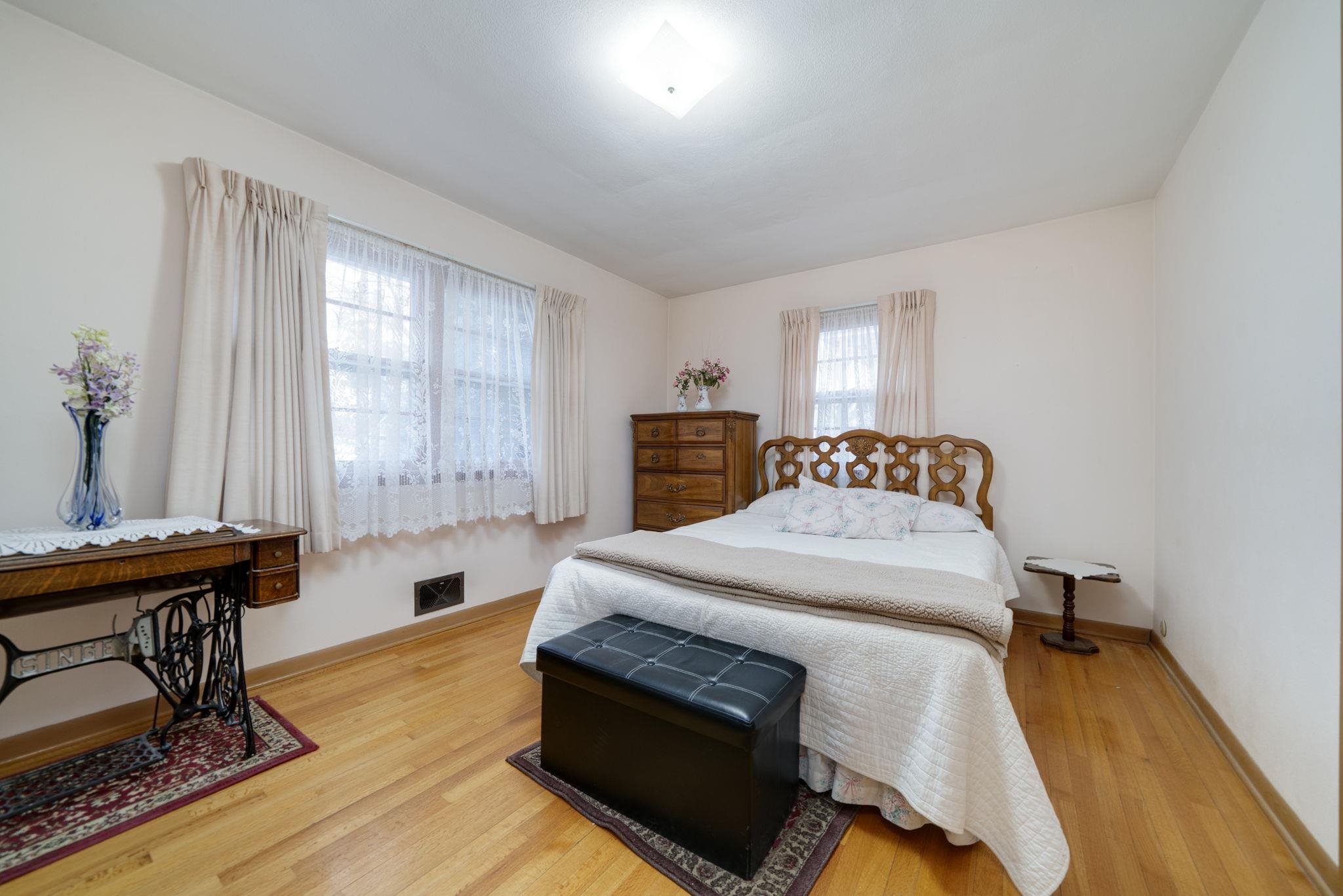 a bedroom with a bed and a table chair