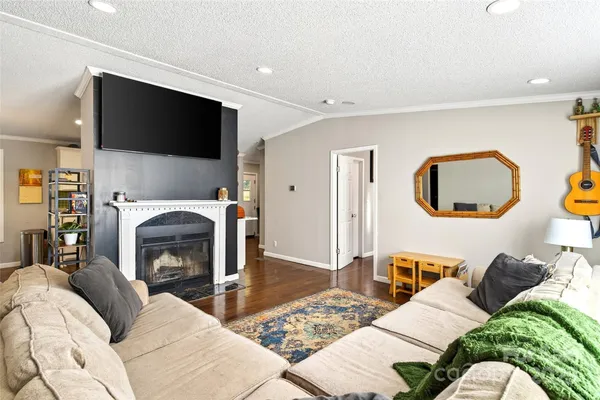 a living room with furniture a flat screen tv and a fireplace