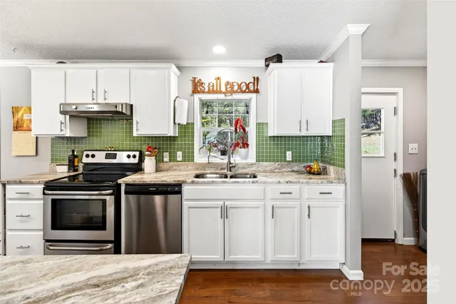 a kitchen with stainless steel appliances granite countertop a stove and a sink