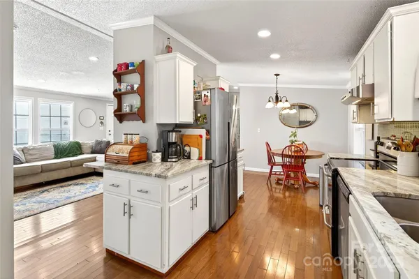 a kitchen with stainless steel appliances granite countertop a stove and a refrigerator