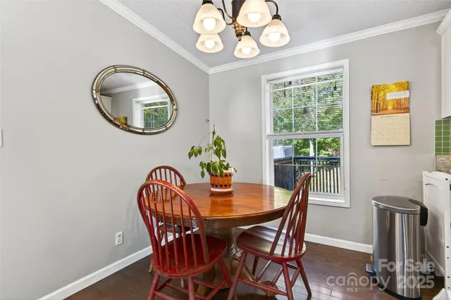 a dining room with furniture a potted plant and wooden floor