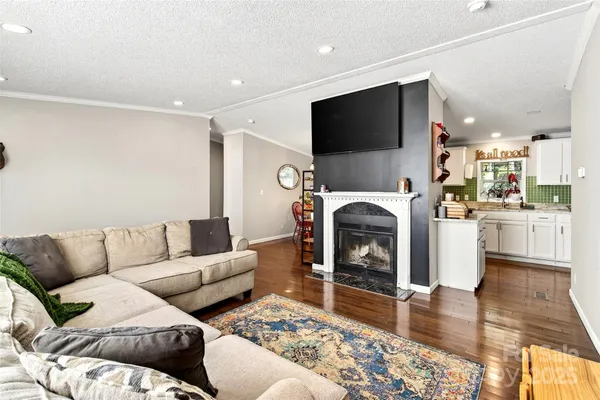 a living room with furniture a flat screen tv and a fireplace