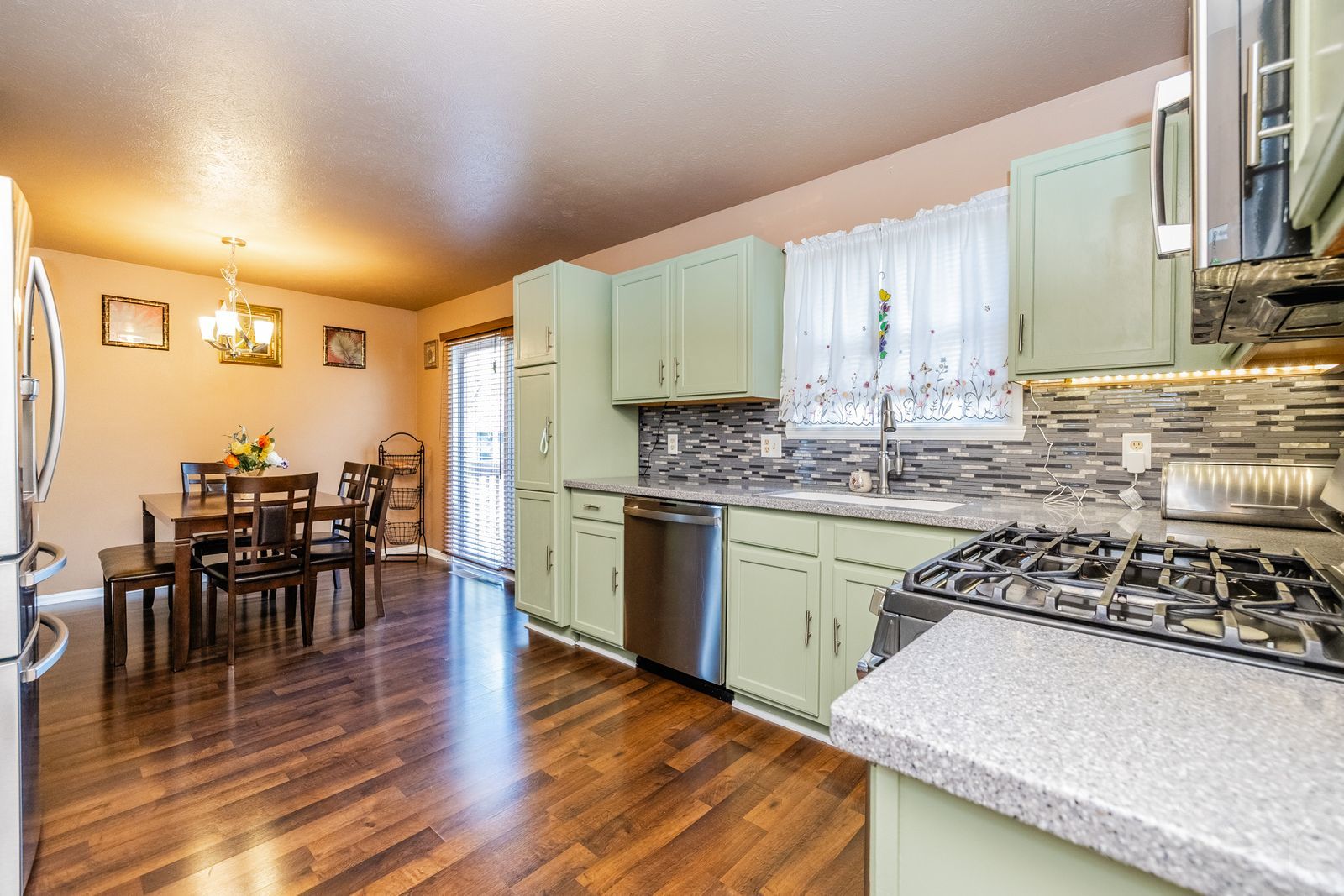 6038 Nimtz Road Loves Park, IL 61111 - Photo 7 of 26 a kitchen with stainless steel appliances granite countertop wooden floors a stove and white cabinets