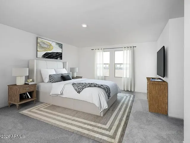 a bedroom with a large bed and a flat tv screen