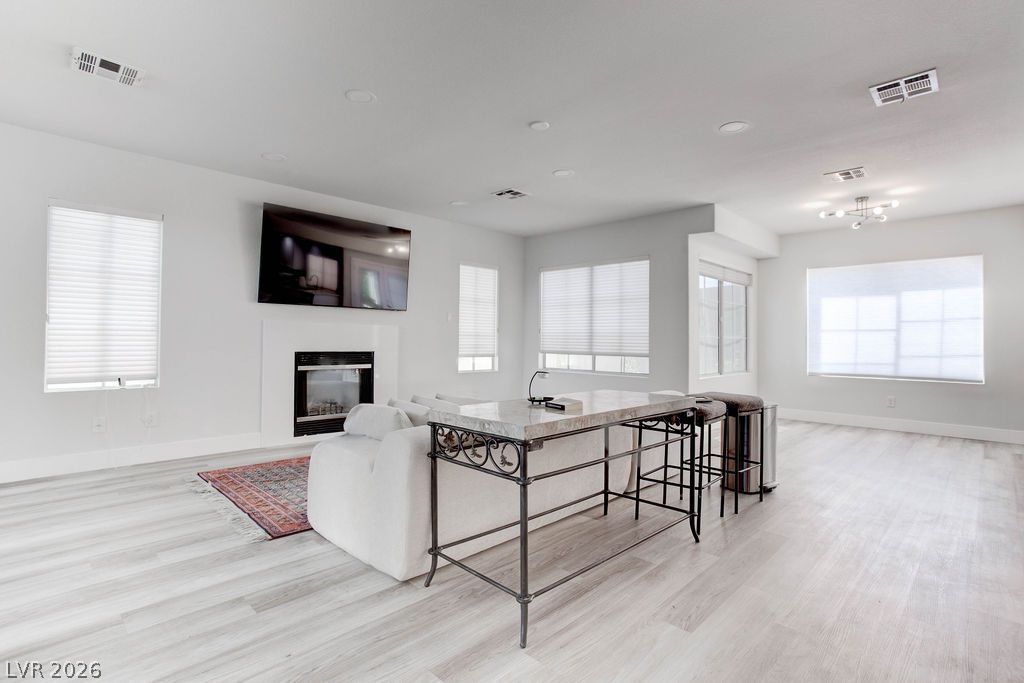 1 Rising Sun Court Henderson, NV 89074 - Photo 7 of 47 A fireplace offers warmth in this inviting living space with light wood-look flooring.