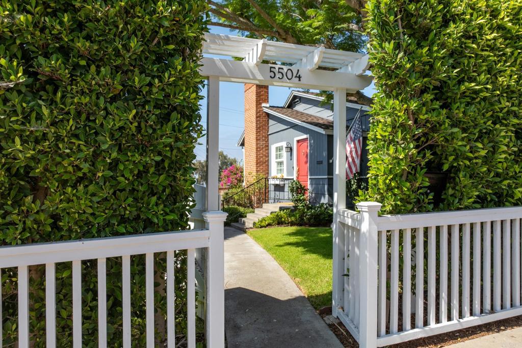 a view of a house with wooden fence and trees