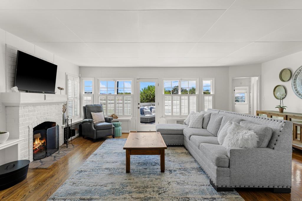 5504 Linda Rosa Avenue La Jolla, CA 92037 - Photo 4 of 24 a living room with furniture a fireplace and a flat screen tv