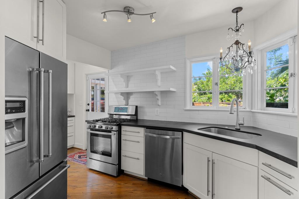 5504 Linda Rosa Avenue La Jolla, CA 92037 - Photo 7 of 24 a kitchen with stainless steel appliances a sink a stove a refrigerator and window
