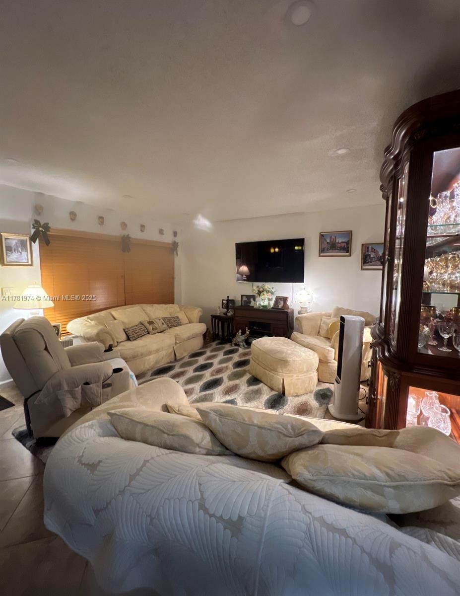 651 Pine Drive, Unit 305 Pompano Beach, FL 33060 - Photo 12 of 21 a living room with furniture and a flat screen tv