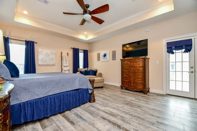 a bedroom with a bed dresser and a flat tv screen
