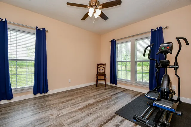 a view of an empty room with window and hardwood floor