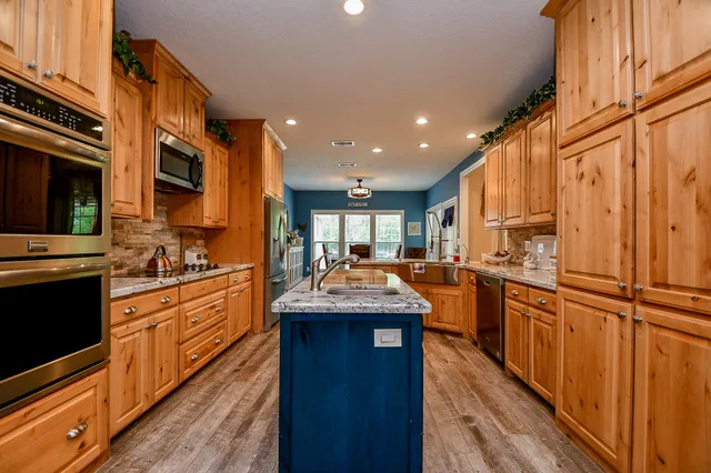 a kitchen with stainless steel appliances granite countertop a sink stove and refrigerator