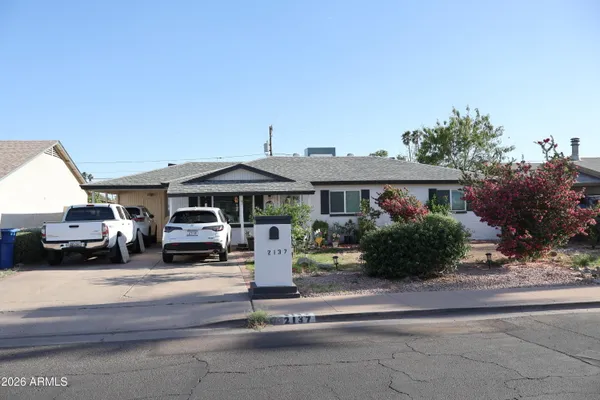 a front view of a house with a garden and parking