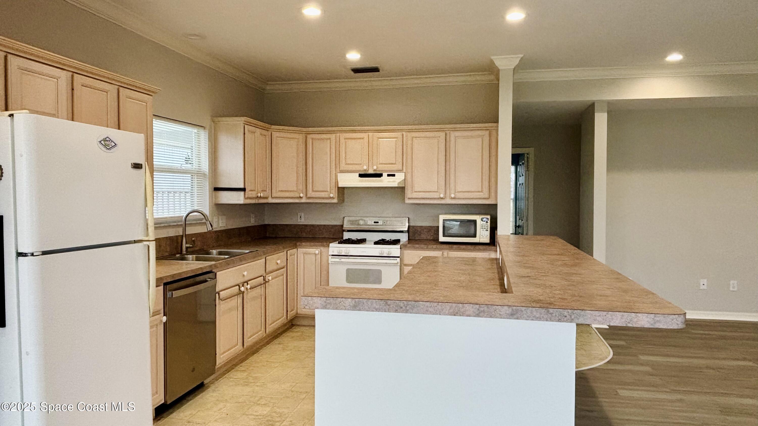 5508 Ambersand Place Grant-Valkaria, FL 32949 - Photo 11 of 30 a kitchen with stainless steel appliances granite countertop a refrigerator a stove and a sink