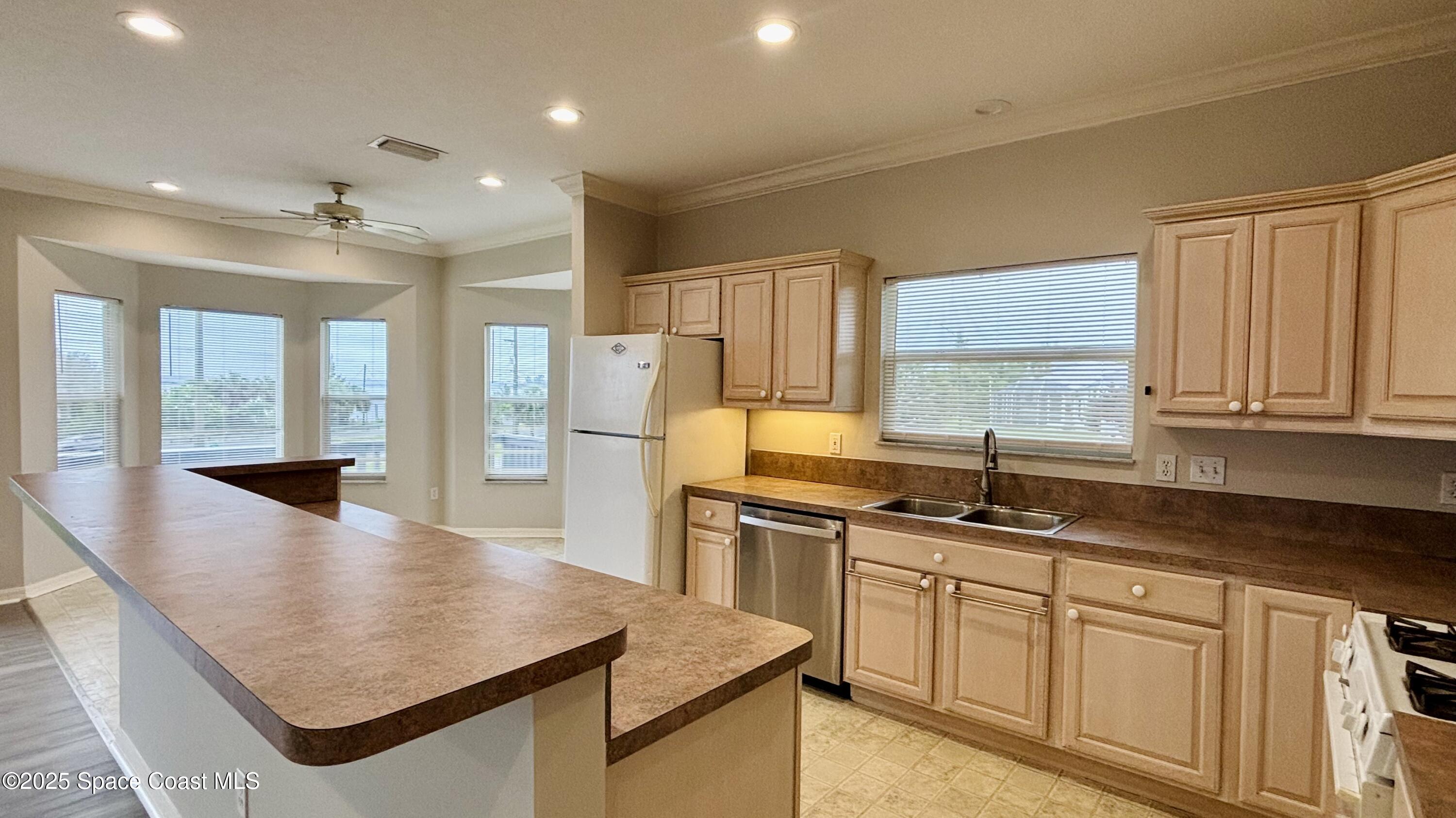 5508 Ambersand Place Grant-Valkaria, FL 32949 - Photo 12 of 30 a kitchen with stainless steel appliances granite countertop a sink a stove and a refrigerator