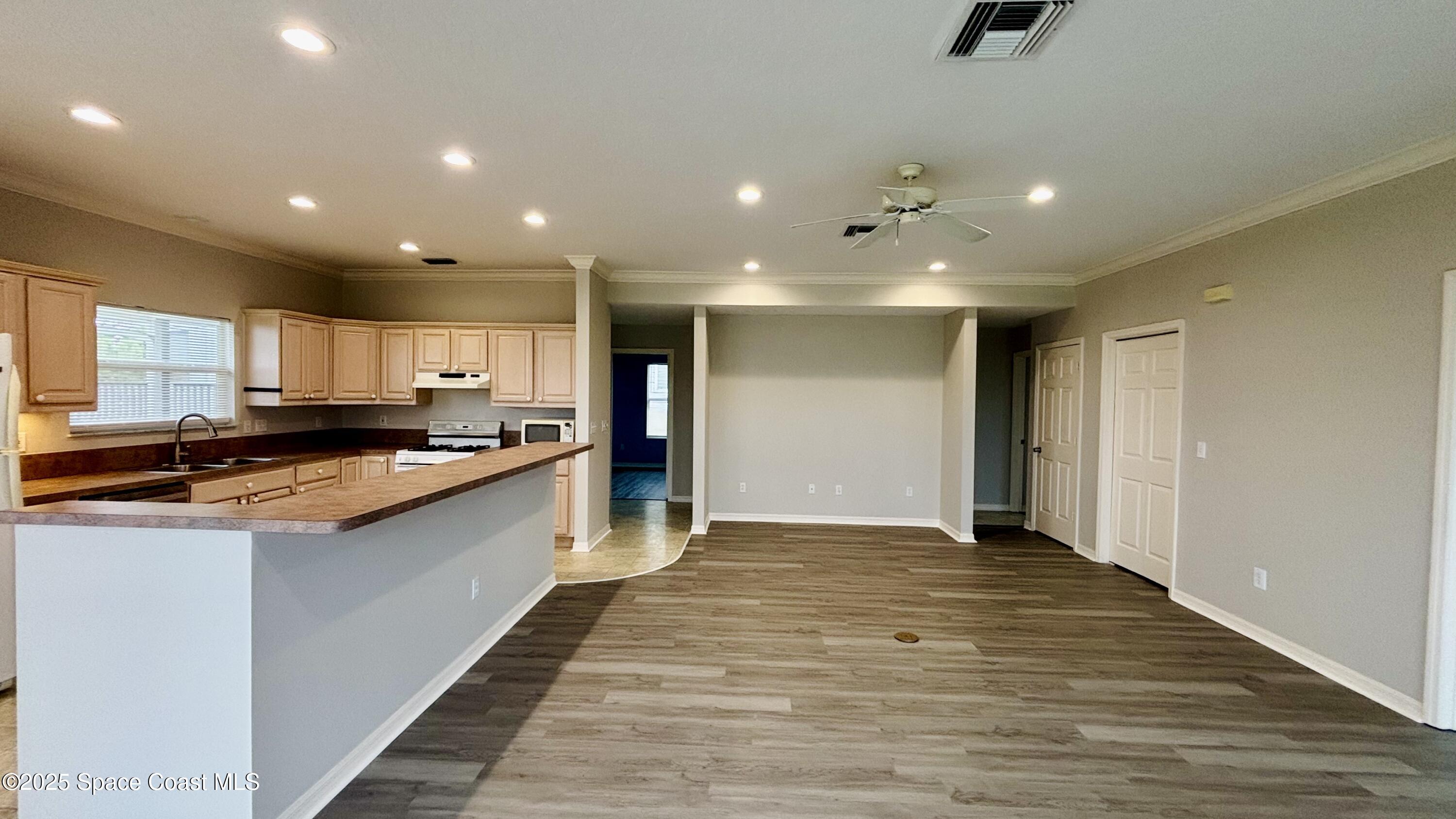5508 Ambersand Place Grant-Valkaria, FL 32949 - Photo 13 of 30 a large kitchen with stainless steel appliances a large counter top a stove and a refrigerator