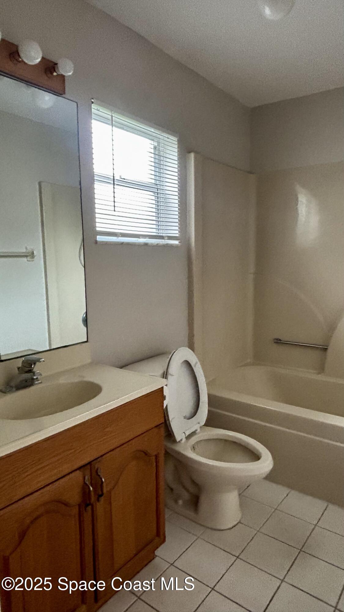 5508 Ambersand Place Grant-Valkaria, FL 32949 - Photo 19 of 30 a bathroom with a granite countertop toilet sink and mirror