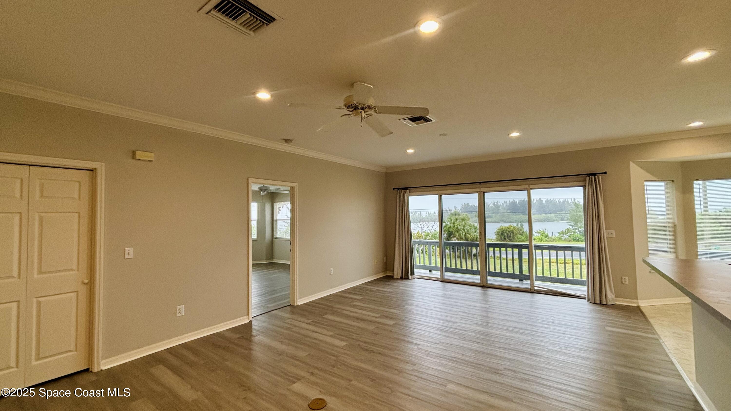 5508 Ambersand Place Grant-Valkaria, FL 32949 - Photo 5 of 30 an empty room with wooden floor and windows