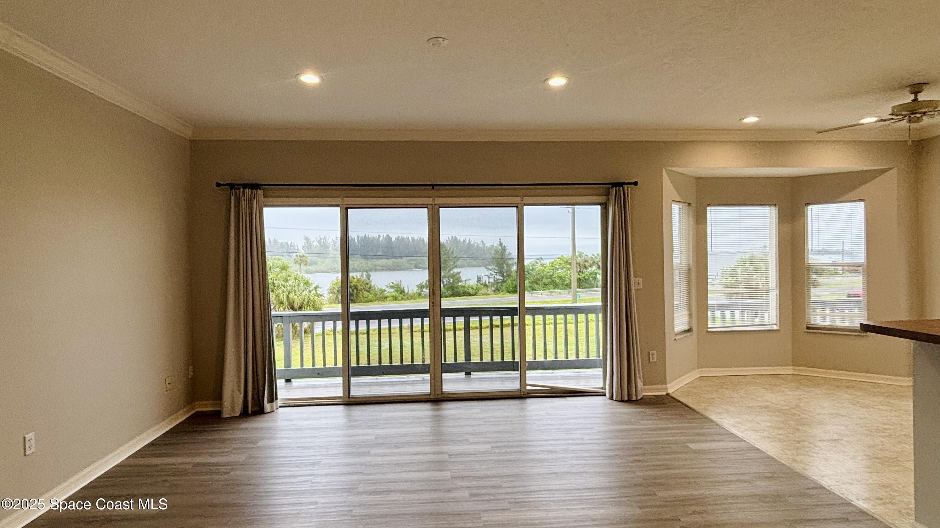 5508 Ambersand Place Grant-Valkaria, FL 32949 - Photo 7 of 30 a view of an empty room with wooden floor and a window