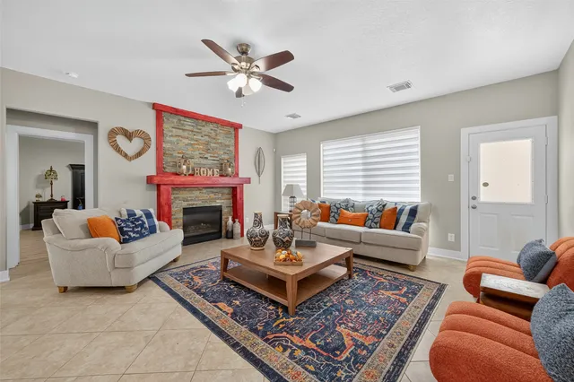 a living room with furniture a fireplace and a large window