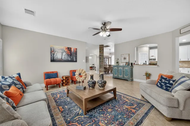a living room with furniture ceiling fan and a rug