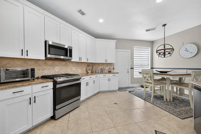 a kitchen with stainless steel appliances a stove a sink a microwave a stove a refrigerator and cabinets