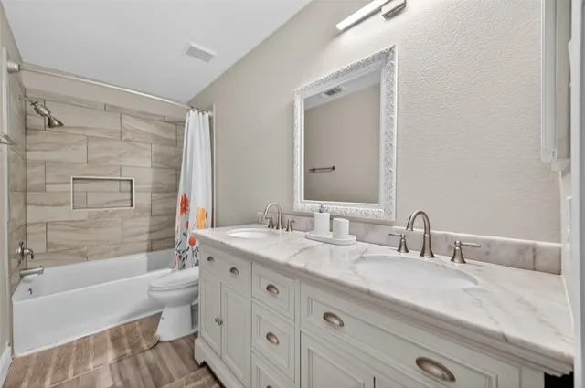 a bathroom with a granite countertop sink mirror toilet and bathtub
