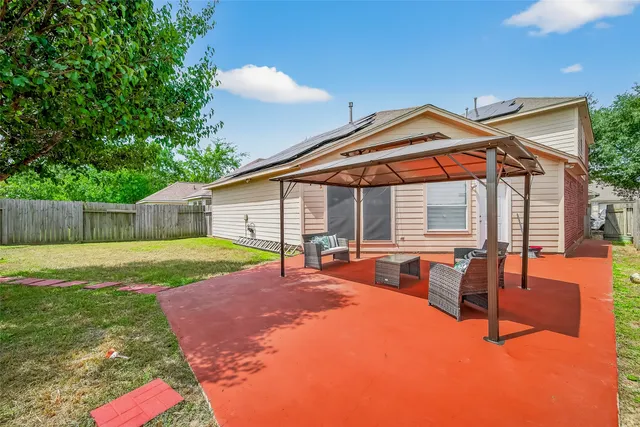 a patio with table and chairs and potted plants