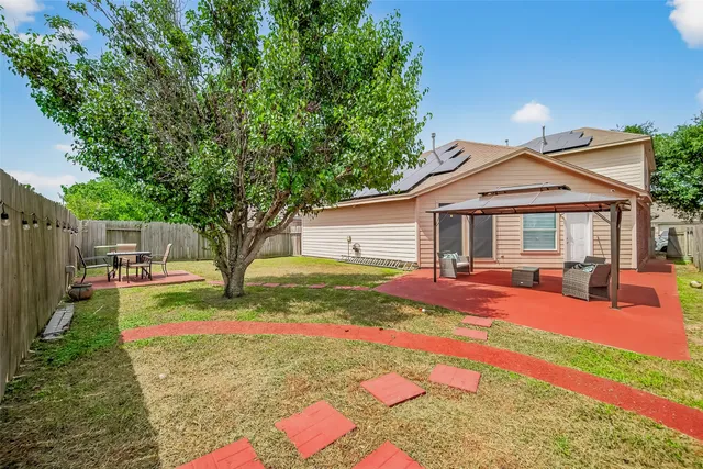 a view of a house with backyard and sitting area