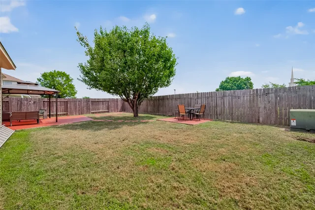a view of a backyard with a garden and tree