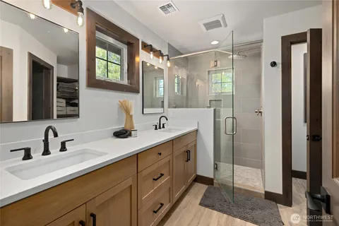 a bathroom with double vanity sinks and a mirror