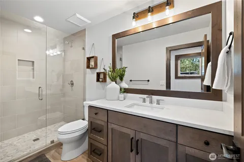 a bathroom with a sink a toilet and shower